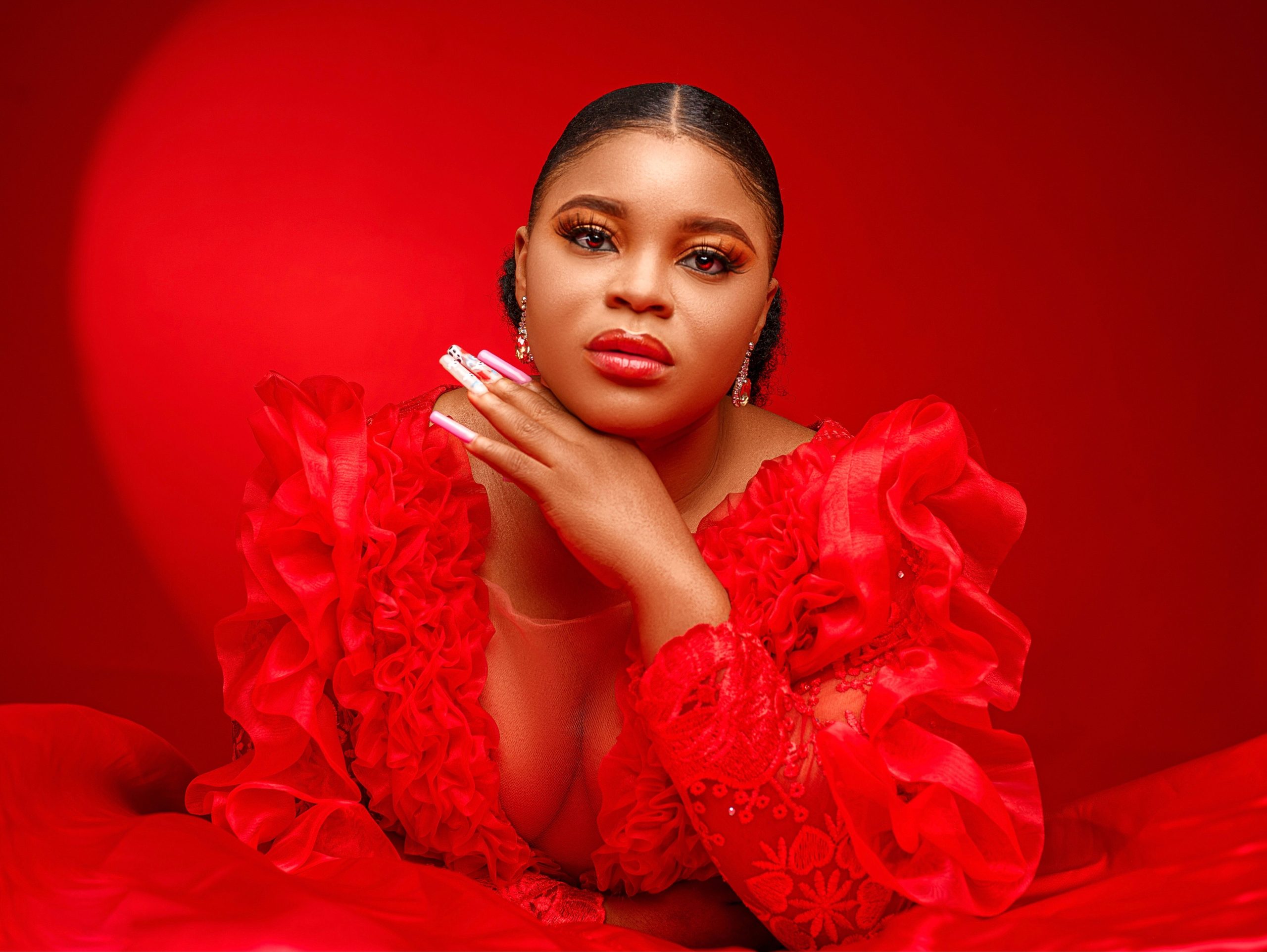 Portrait of an elegant woman in a vibrant red gown, showcasing fashion and beauty.